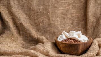 Cocoa powder in a wooden bowl on a brown cloth background photo