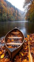 A rowboat sits on the shore of a river in autumn photo