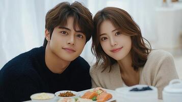 A couple posing for a photo with food on a table
