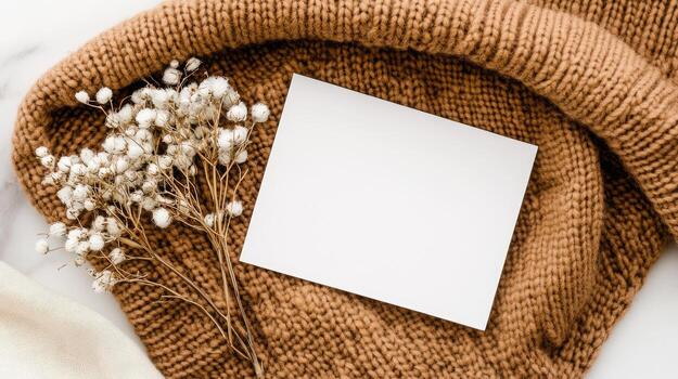 Blank card on a knitted sweater and a white flower on a white background photo
