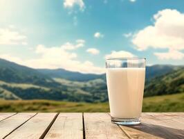 Glass of milk on wooden table with mountains in background photo