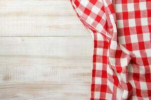 Red and white checkered tablecloth on wooden table photo