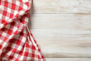 Checkered red and white tablecloth on wooden background photo