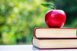 A stack of books and an apple on a table photo