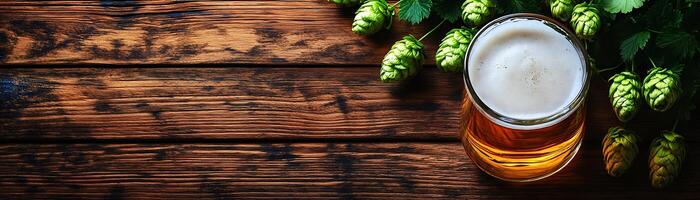 A glass of beer and some hops on a wooden table photo