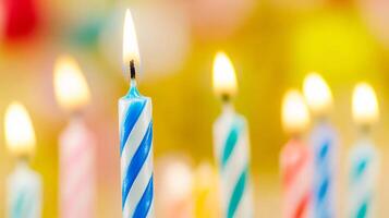 Many colorful birthday candles are lit up in a row photo