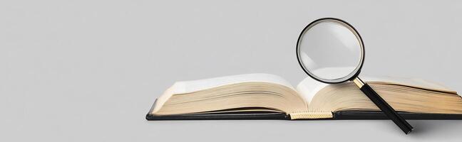 An open book with a magnifying glass on top photo