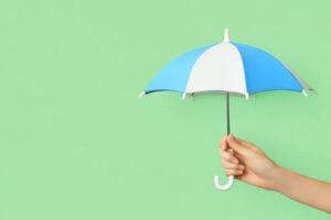 A person holding an umbrella over a green background photo