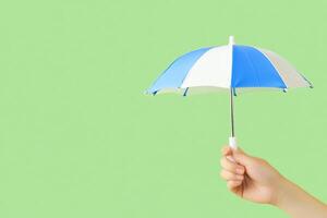 A person holding an umbrella over a green background photo