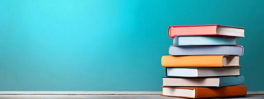 Stack of books on wooden table against blue background photo