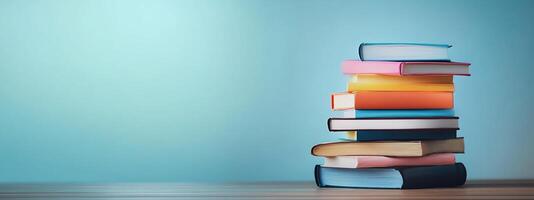 Stack of books on wooden table with blue background photo