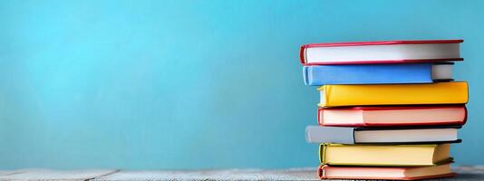 Stack of books on wooden table with blue background photo