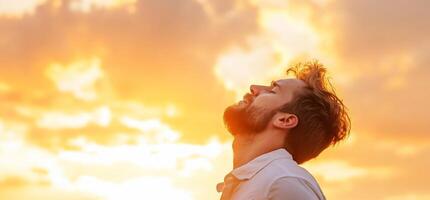 A man is looking up at the sky at sunset photo