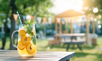 A pitcher of lemonade with peaches on a table photo