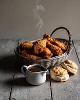 Fried chicken and biscuits in a basket on a wooden table photo