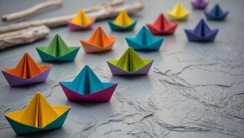 Colorful paper boats on textured gray background create a playful maritime display photo