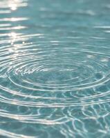 water texture background with sunlight reflection and ripples in a turquoise blue color photo