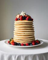 Tower of Pancakes Topped with Fresh Berries and Cream on Buffet Table photo