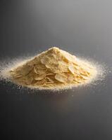 Nutritional Yeast Flakes Pile on Black Background with Fine Texture and Depth of Field photo