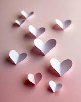 Intricately cut paper hearts on a soft pink background for a valentine s day card composition photo