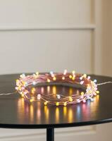 A colorful string of lights is curled up on a table photo