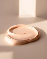 Creamy texture applied on a surface in bright light showcases a subtle peach color photo