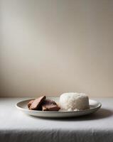 A simple meal of rice and meat served on a white plate photo