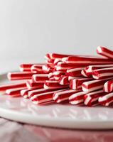 A bunch of red and white striped candy sticks photo