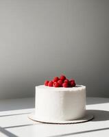 A white cake with a white frosting and red berries on top photo
