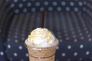 A cup of iced coffee with whipped cream and a chocolate bar photo