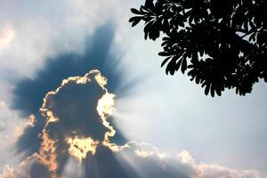 A cloud with sun rays shining through it photo