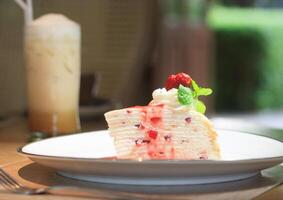 A piece of cake on a plate with a drink photo