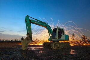 A construction machine is in the foreground with sparks photo