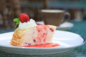 A piece of cake on a plate with a cup of coffee photo