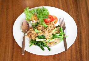 A white plate topped with a salad and a fork photo