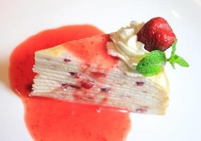 A piece of cake with strawberries and whipped cream photo