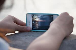 A person holding a cell phone with a photo on it