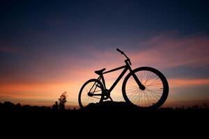 Silhouette of a bicycle against a sunset sky photo