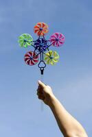 A person holding a colorful pinwheel in the air photo