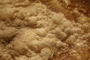 Macro of powdery bubbles in orange liquid photo