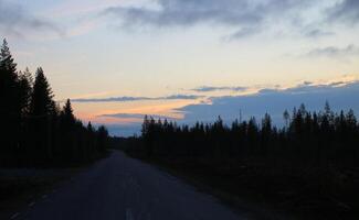 Light colored sunset and dark landscape in Northern Sweden photo