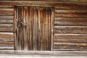 Old and rustic hatch on a log hut photo