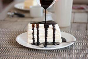 A piece of cake on a plate with a drizzle of chocolate sauce photo