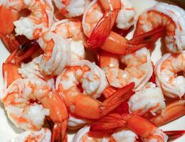 A bowl of cooked shrimp sitting on a table photo