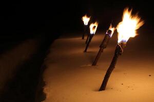 Row of burning torches in the snow photo
