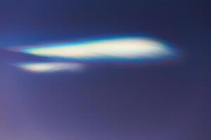 Nacreous cloud in dusk on a blue sky photo