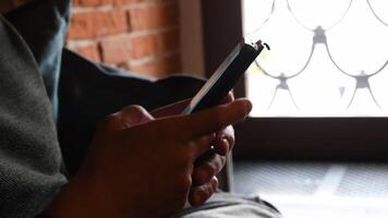 Young man hands hold cell phone tapping and browsing internet on smartphone. Closeup mobile phone using. Texting digital messages to connecting with friends video