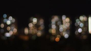 Artistic noise filter night shot of blurry glowing blinking city lights. Urban abstract background with bokeh defocused lights from skyscraper windows on black backdrop of night sky video