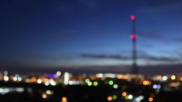 Intentional blur city abstract background. Evening over city with bokeh blinking lights at urban skyline with blurry silhouette of tower in dark sky. Urban abstraction video