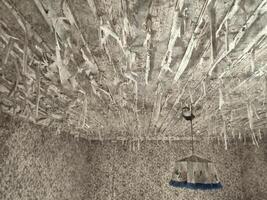 Paint flakes hanging from the ceiling in an abandoned house photo